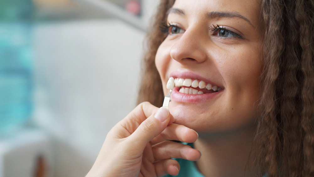Woman receiving professional teeth whitening treatment from a dentist.
